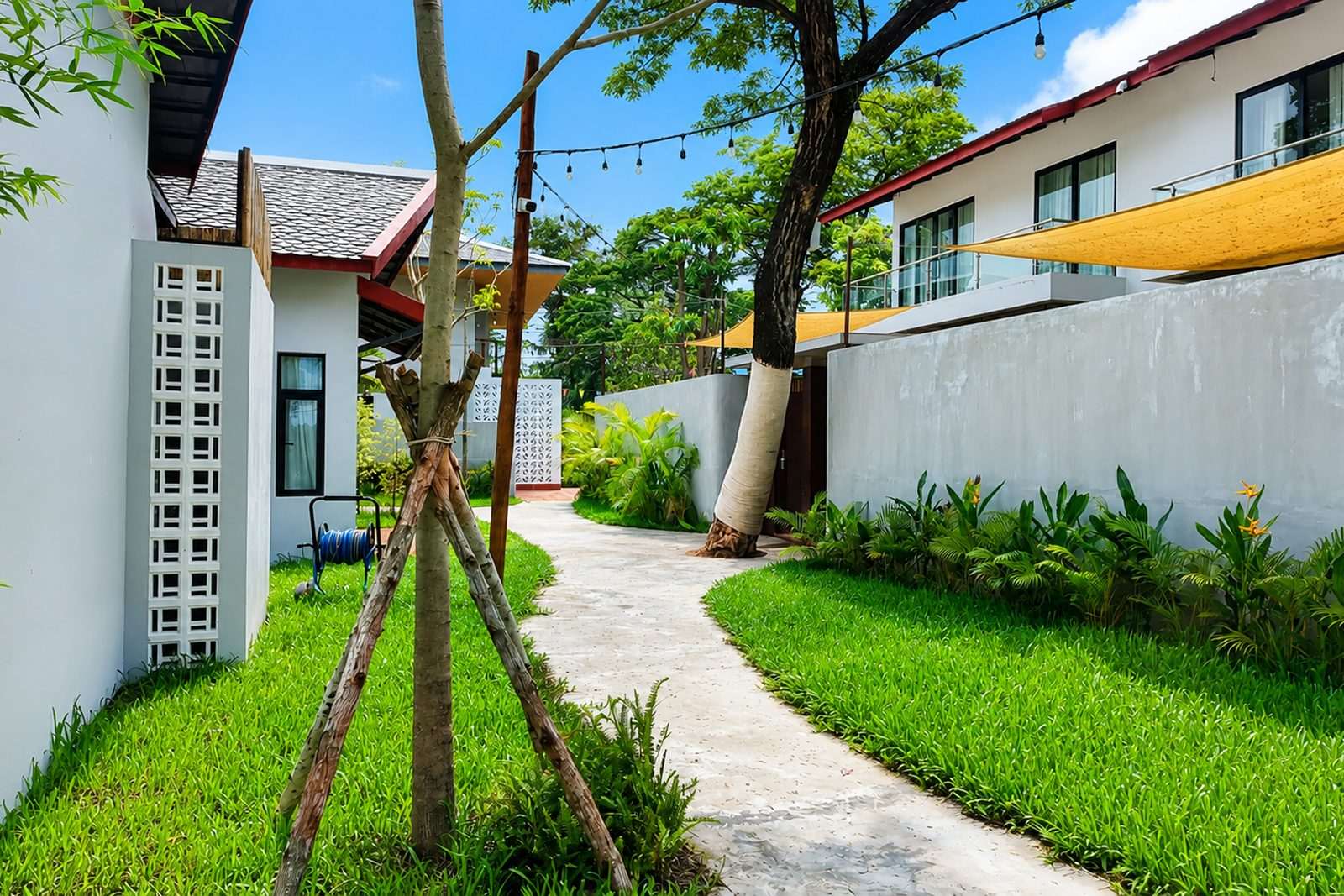 A shaded garden walkway between the rooms